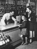 Mother and Daughter (8-9) Standing at Counter, Talking To Shop Assistant