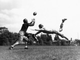 American Football Players Tackling Football in Mid-Air