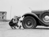 Woman Changing Flat Tire on Car