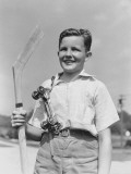 Boy Holding Hockey Stick, Metal Roller Skates Hanging on His Shoulder