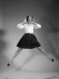 Woman Doing Cheerleader Jump, Hand Up To Mouth, Yelling and Screaming