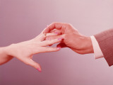Man Placing Engagement Ring on Woman
