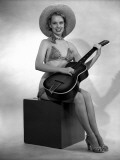 Studio Portrait of Young Woman in Bikini Playing Guitar