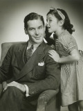 Daughter (8-9) Whispering Into Father's Ear
