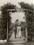 Romantic Couple Walking Through Rose Arbor