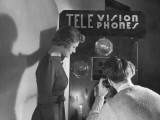 Man and Woman Using Telephone With Video Hookup