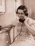 Woman Holding Telephone and Pencil in Kitchen