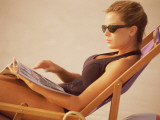 Woman Sitting on Canvas Beach Chair, Suntanning