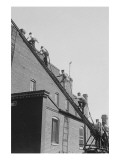 A Team of Firefighters With Hoses on Their Backs Climbs a Ladder