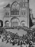 Pilgrims Kneeling to Pray in Front of Cathedral During Pilgrimage for Peace