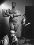 Sculptor Marino Marini Crouching in Front of One of His Sculptures with His Wife Standing Behind