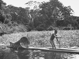A Local Citizen Rowing a Native Boat with an Onboard Fishing Trap for Picture 