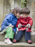 Twins Share their Ipods While Sitting on Stairs