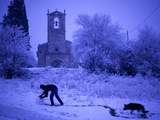 Buy A Man Rolls a Ball of Snow Near the Church in Porqueres at AllPosters.com