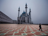 A Woman Walks across a Square Near the Qolsharif Mosque