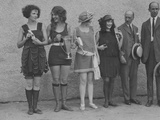 Girls in Summery Attire Hold Cup, Ribbons, and Awards They