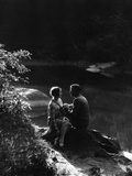 1920s 1930s Romantic Couple Sitting By Stream In Soft Moody Afternoon Sunlight