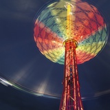 Illuminated chairoplane against dark sky