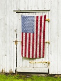 American flag draped,door of barn