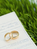 Wedding rings and marriage certificate on grass