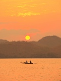 Father and daughter fishing at sunset near Lewolin Village