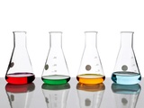 Four conical flasks holding different colored fluids