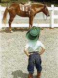 Young Cowboy Looking at Horse