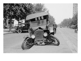 Automobile's Front Axel Breaks Splaying Tires Outward Causing Vehicle to Rest on its Front Bumper.