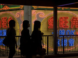 Women Walk Past Neon Signs in the Mong Kok District