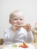 Small Boy at Breakfast with Half a Bread Roll
