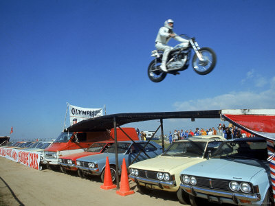 Daredevil Motorcyclist Evil Knievel in Mid Jump over a Row of Cars Premium 