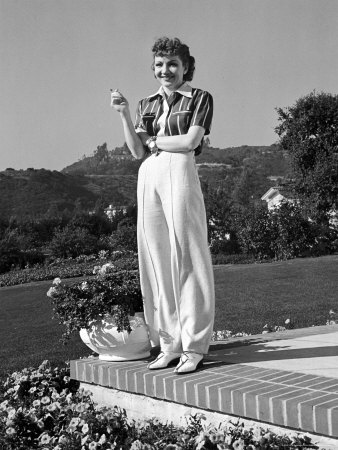 Actress Claudette Colbert Holding Cigarette as She Suns Herself on Terrace
