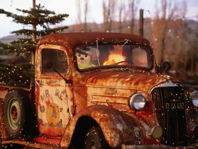 Rusty Old Truck Strung with Christmas Lights with Santa Claus at Wheel 