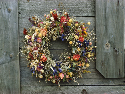 A Delicate Dried Flower Wreath Adorns a Wooden Wall Near a Window Stretched Canvas Print
