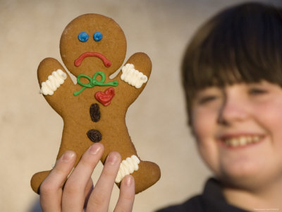 "A Gingerbread Cookie Looks Sad While Being Held in a Male's Hand" Photographic Print "A Gingerbread Cookie Looks Sad While Being Held in a Male's Hand" Photographic Print