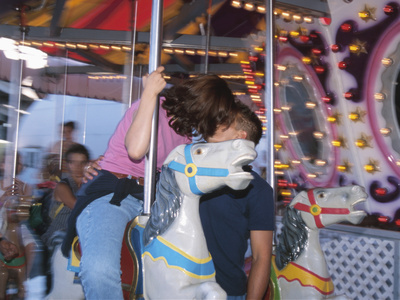 Young Couple Kissing on Carousel Photographic Print Young Couple Kissing on Carousel Photographic Print