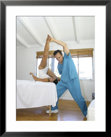 Man Helping a Young Woman Stretch Framed Print Man Helping a Young Woman Stretch Framed Print