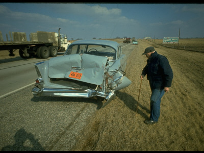 Man Inspecting Extensive Damage to Rear of His Car after Accident Stretched Canvas Print