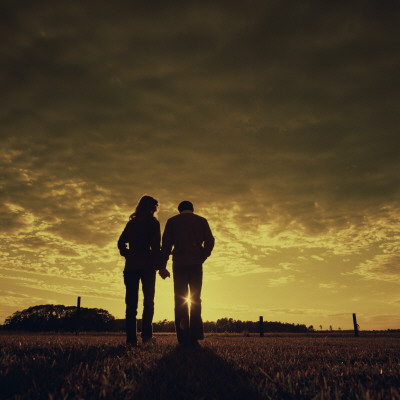 couple holding hands in sunset. Couple Walking at Sunset