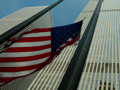pictures of american flag waving. Skyward View of an American Flag Waving in Front of Skyscrapers Photographic