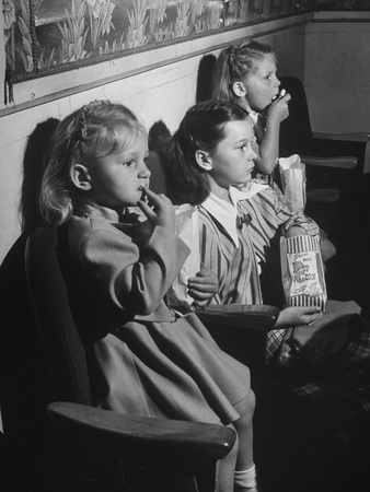 Little Girls Quietly Watching a Movie While Munching on their Popcorn Stretched Canvas Print