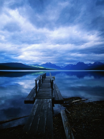 Pier at Lake McDonald Under Clouds Stretched Canvas Print