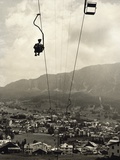 Man Riding Chair Lift Above Town