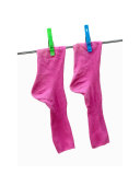 Pink socks with green and blue clothes pins on a washing line