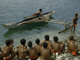 Boys Watch a Man Push Off in an Outrigger Canoe for a Boat Race