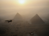 The Vimy flies above fog-shrouded pyramids during a golden sunrise at Giza