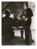 Man Plays a Piano and Looks up at a Glamorous Woman in a Long Dress