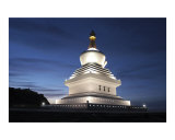 White iluminated Buddhist stupa with blue sky background