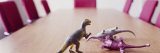 Three Dinosaur Toys on a Conference Table
