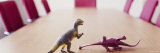 Two Dinosaur Toys on a Conference Table